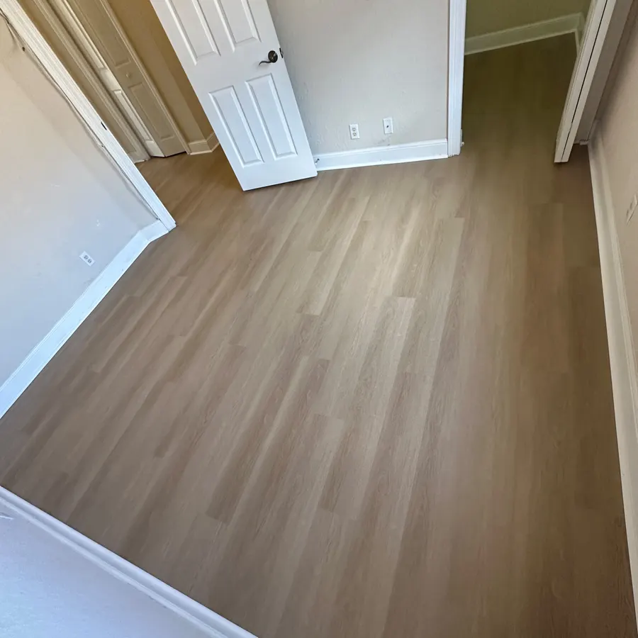 Finished wood-look plank flooring across a bedroom